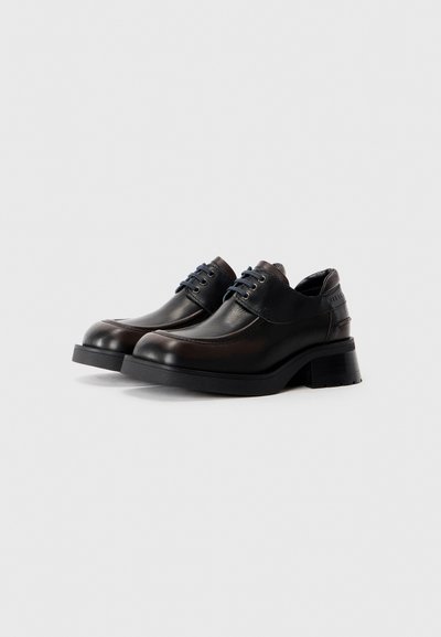 Brown leather shoes with a rounded toe, two-tone design, blue laces, and a chunky heel. Features smooth texture and subtle stitching accents.