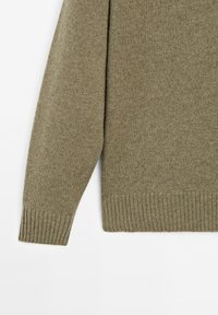 Langzaam korte mouwen khaki groene wollen gebreide trui met ribgebreide manchetten en zoom, weergegeven tegen een witte achtergrond.