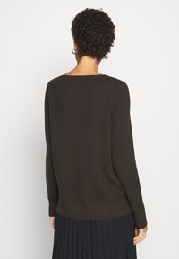 Dunkelgrüner Pullover mit lockerer Passform, weitem Ausschnitt und gerippten Bündchen. Hergestellt aus weichem Strickmaterial, mit geradem Saum.