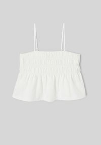 Crop top blanc sans manches avec bretelles fines réglables et corsage froncé sur fond gris.