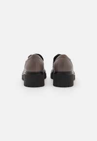 Brown leather shoes with a smooth texture and a thick black rubber sole. Features rounded back and minimalistic design.