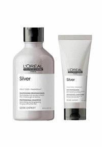 Shampoo- und Conditionerflaschen von L’Oréal Professionnel in Silber mit schwarzen Kappen, gekennzeichnet zur Neutralisierung und Auffrischung von grauem und weißem Haar.