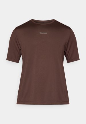 Bruin T-shirt met korte mouwen van gestructureerde stof, voorzien van een ronde hals en een klein wit logo op de borst.