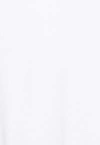 Lyhythihainen valkoinen t-paita, joka on valmistettu puuvillasta. Sen pinta on sileä ja muotoilu on yksinkertainen, ilman näkyviä kuvioita tai koristeita.