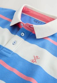 Koszulka polo z białym kołnierzykiem, poziome niebieskie, białe i różowe paski, dwie niebieskie guziki oraz małe różowe haftowane logo.