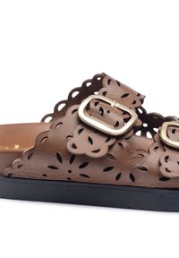 Sandal in pelle marrone con design floreale a intaglio, due fibbie d'oro regolabili e suola in gomma nera.