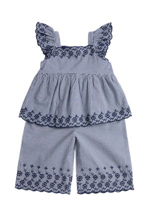 To-delt outfit med marineblåt og hvidt ternet mønster, med flæse stropper og broderede blomsterkanter på toppen og vidde shorts.