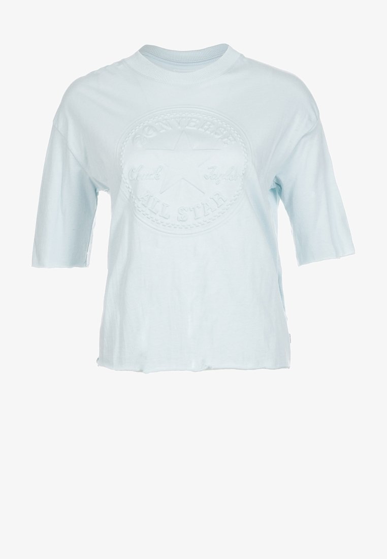 Jasnoniebieska bawełniana koszulka z krótkim rękawem, posiadająca teksturowane, okrągłe logo z gwiazdą i napisem "Converse All Star". Luźny krój.