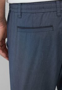 Donkerblauwe broek van een geweven stof, met een gestikt achterzak en een elastische tailleband voor comfort.