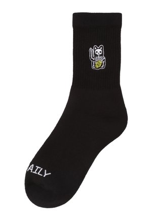 Schwarze Socke mit einem kleinen Skelett einer Katze, die eine gelbe Münze hält, nahe der Oberseite und weißem Text mit "DAILY" am Zehenbereich.