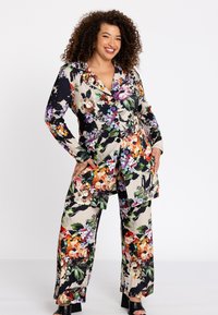 Een bloemenprintset in meerdere kleuren met een blazer met een reverskraag en lange mouwen, gecombineerd met wijde broekspijpen. Glad stofmateriaal.