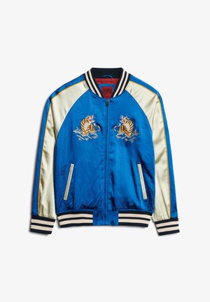 Niebieska satynowa kurtka bomberka z kremowymi satynowymi rękawami, wyszywanymi tygrysami na klatce piersiowej, prążkowanymi ściągaczami przy mankietach i na dolnej krawędzi, z zamkiem z przodu oraz bocznymi kieszeniami.
