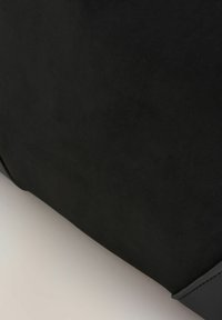 Must tume nahkakott sileda tekstuuri ja struktureeritud disainiga. Omab ümarate nurkade ja mati viimistlusega. Sujuv ja minimalistlik välimus.