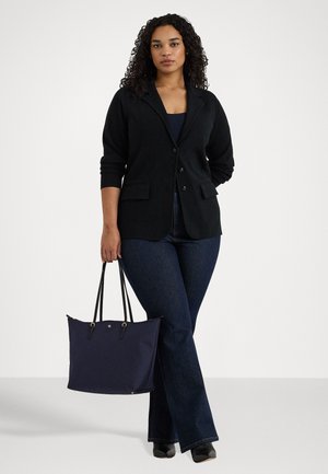 Blazer preto com colarinho em ângulo, três botões e dois bolsos frontais. Combinado com jeans flare de lavagem escura e uma bolsa azul-marinho.