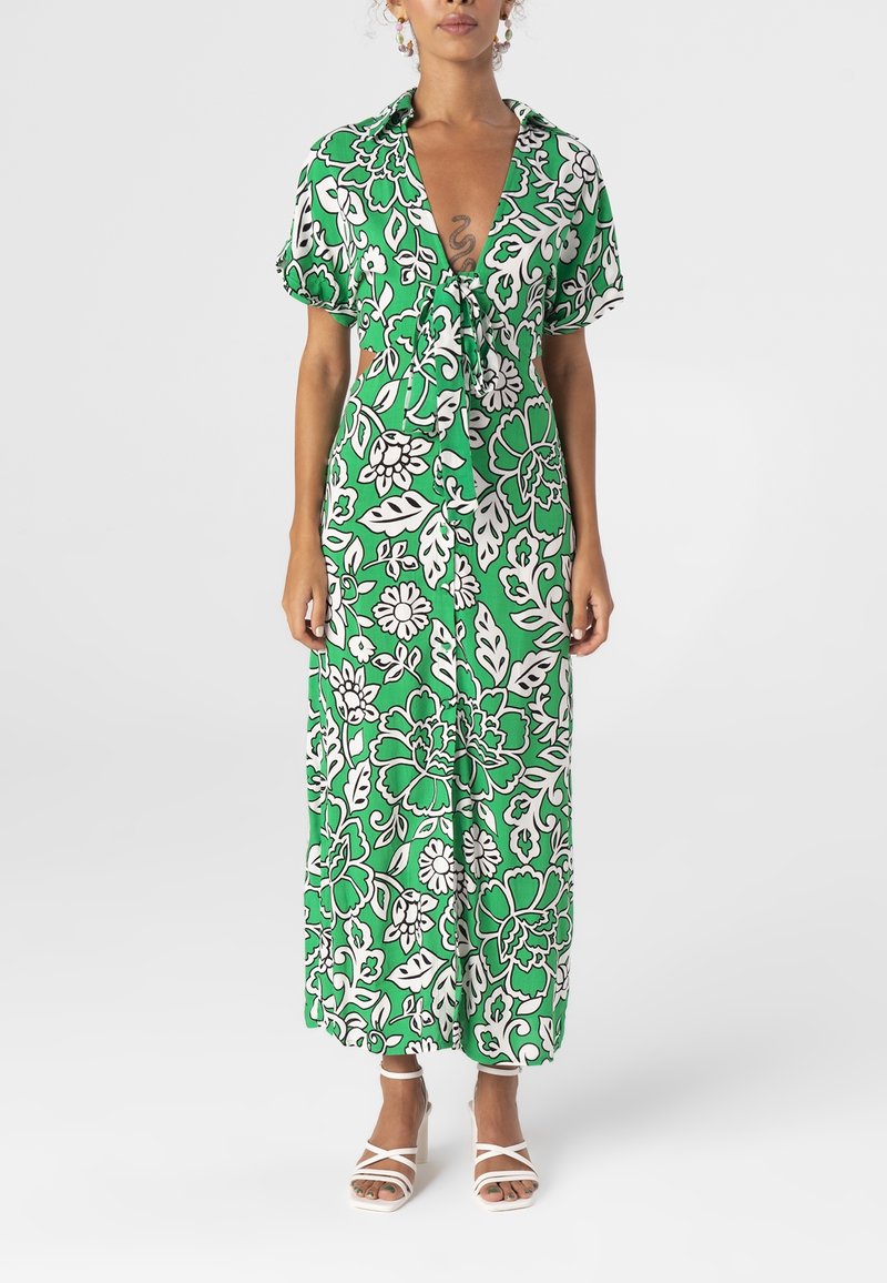 Groene bloemenjurk met korte mouwen, strik aan de voorkant, met witte en lichtgroene bloempatronen op een donkergroene achtergrond.