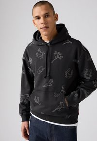 Zwarte hoodie van katoen, met witte lijnillustraties van dieren en objecten, voorzien van een voorzak en een capuchon met trekkoord.
