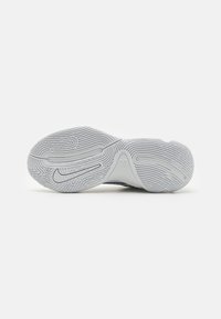 Hvid sneakersåle med detaljeret dækmønster, prægede Nike swoosh og indgraverede navne på en ganske almindelig hvid baggrund.