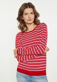Pulover cu dungi roșii și albe, cu mâneci lungi și decolteu rotund, cu manșete și tiv din material rib. Țesătura pare netedă și ușoară.