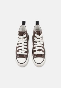 High-Top-Sneaker aus dunkelbraunem Canvas mit weißen Schnürsenkeln, Gummikappen an den Zehen und kontrastierenden schwarzen Fersenschlaufen. Verfügt über strukturierte Laufsohlen.