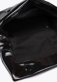 Otvorena crna torba s visokim sjajem, s tkaninom unutar i malim zatvorenim džepom sa strane.