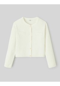 Cardigan court blanc avec un motif en relief texturé, encolure ronde et petites poches poitrine. Fermé avec des boutons légers.