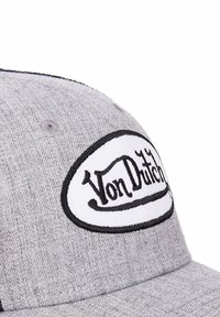 Casquette grise en tissu texturé, ornée d'un patch ovale blanc avec une broderie noire portant la mention "Von Dutch". Visière incurvée et réglable à l'arrière.