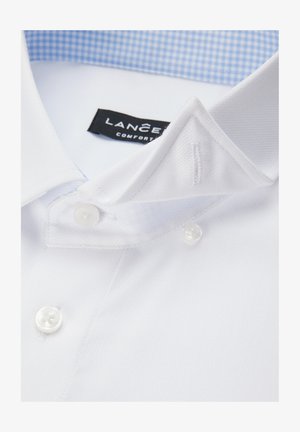 Biała bawełniana koszula z fakturowanym wykończeniem, z niebieskim, kratkowanym wewnętrznym kołnierzykiem i dwoma białymi plastikowymi guzikami na plisie.