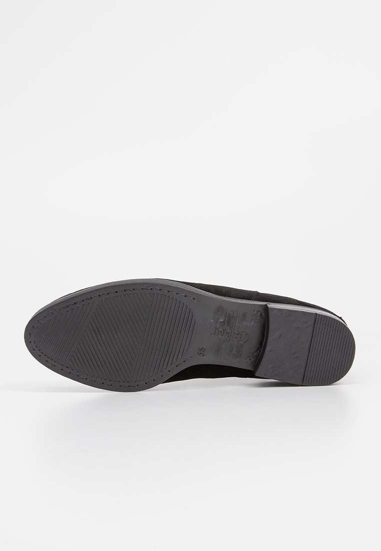 Schwarzer Schuh mit einem strukturierten Wildleder-Obermaterial und einer Gummisohle. Verfügt über ein flaches Design mit einer leicht abgerundeten Spitze und einem gemusterten Profil.
