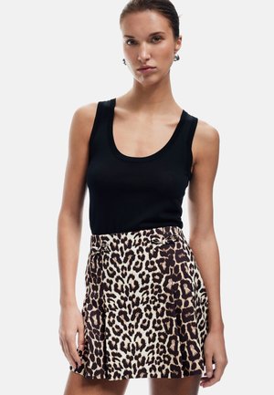 Zwarte mouwloze top en een leopardenprint plissé rok met beige en bruine tinten; bevat strikken bij de taille en heeft een gladde stoftextuur.