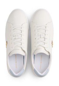 Bijele kožne tenisice s vezicama, svijetloplavi detalji na peti i zlatni logo. Imaju teksturiranu bočnu ploču.