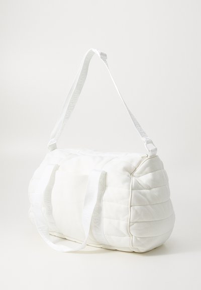 White quilted duffel bag with padded texture. Features two white handles and an adjustable shoulder strap with logo detail.