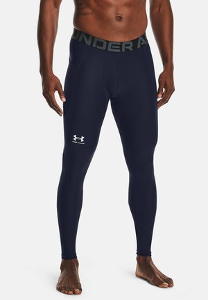 Navyblaue feuchtigkeitsableitende Leggings mit tailliertem Schnitt. Verfügt über einen grauen, markierten Bund und ein kleines weißes Logo am linken Oberschenkel.