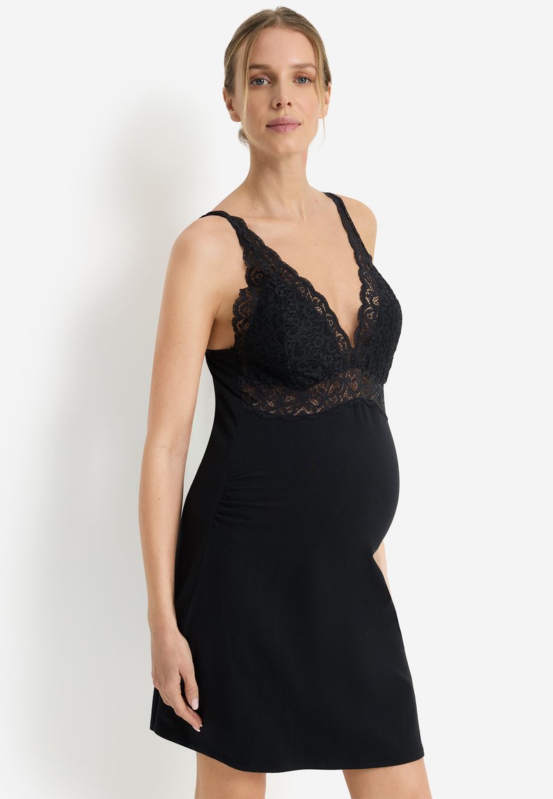 Μαύρο νυχτικό εγκυμοσύνης με βαθύ δαντελένιο ντεκολτέ, ρυθμιζόμενους ιμάντες και απαλό, ελαστ ικό ύφασμα. Διαθέτει πιέτες στα πλαϊνά.