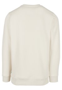 Sweat-shirt uni à manches longues couleur crème, vu de dos, avec poignets et ourlet côtelés, sans logos ni motifs visibles.