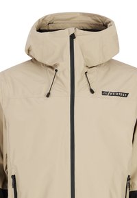 Vaurio unisex-beige vaate takki, jossa on korkea kaulus ja säädettävä huppu. Takissa on etuvetoketju ja mustat yksityiskohdat vetoketjussa ja taskuissa.