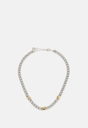 Silver chain necklace featuring pyramid accents, alternating gold-tone metal studs. Adjustable clasp with a small extension chain.