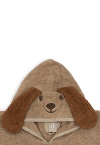 Serviette à capuche en doux tissu éponge beige, arborant un design de visage de chien avec des oreilles brunes et des détails brodés ; taille unique.