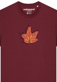 Bordeaux T-shirt met een geometrische oranje en gele esdoornblad grafiek op de voorkant. Zachte stof met een ronde hals.