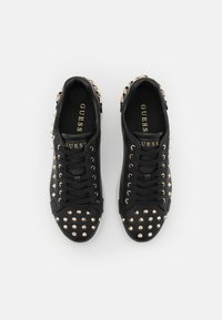 Sneakers in pelle nera con dettagli in oro a borchie, punta rotonda, design con lacci e colletto imbottito. Nome del marchio visibile all'interno.