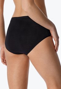 Culotte noire taille haute avec une texture côtelée, une taille élastique douce et des bords lisses, conçue pour le confort et la couvrance.