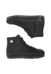 Melni augsti teksturēti sporta apavi ar biezām gumijas zolēm, priekšpusē ar šņorēm, vienā apavā sānu rāvējslēdzējs un balts zīmola logotips uz papēža.