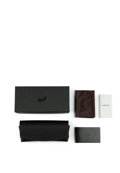 Étui à lunettes Persol noir, boîte Persol noire, chiffon de nettoyage marron, livret et carte Luxottica blanche sur fond blanc.