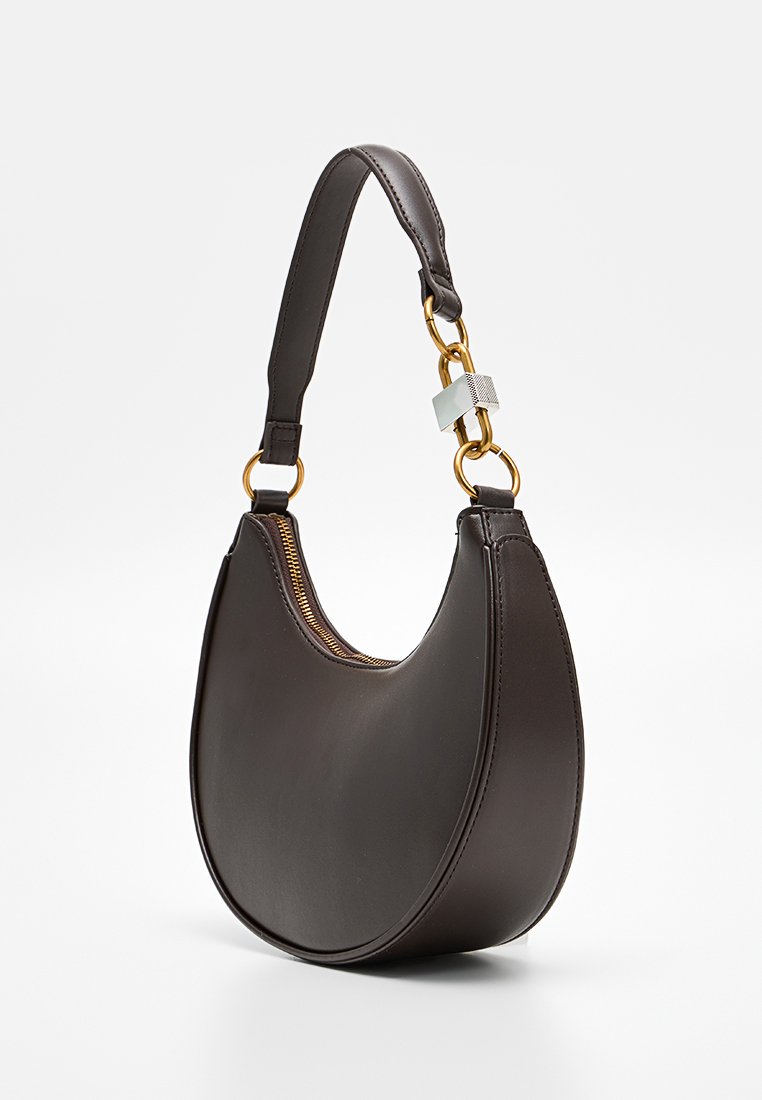 Borsa a tracolla in pelle marrone con forma curva, accessori in oro, chiusura con zip e una sola tracolla. Texture liscia senza motivi visibili.