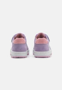 Lilla semskede sneakers med rosa detaljer, med borrelåsrem og hvit såle med rosa yttersåle. Glatt tekstur og rund design.