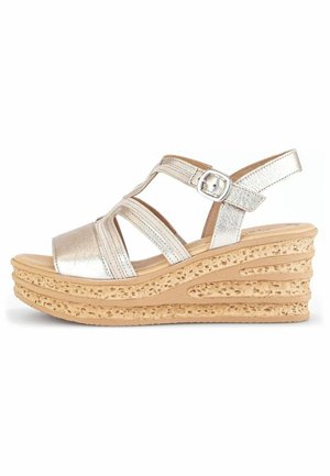 Metallic silver wedge sandal with crisscross straps, buckle closure, and textured, natural-colored platform featuring cut-out detailing.
