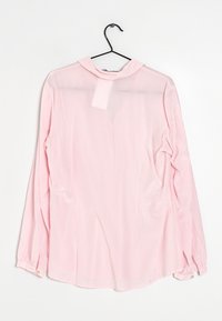 Blusa de manga larga color rosa claro con un cuello, hecha de una tela delgada y ligeramente translúcida. Cuenta con puños abotonados, textura suave y corte recto.