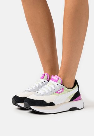 Sneakers med ett vitt mesh-övre, svarta mockadetaljer, grå överlägg och rosa logotypdetaljer på tungan och hälen. Tjock vit sula.