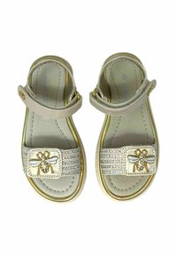 Sandali beige chiaro con una cinghia dorata e una fibbia decorativa con design di ape, abbelliti con strass nella parte anteriore.