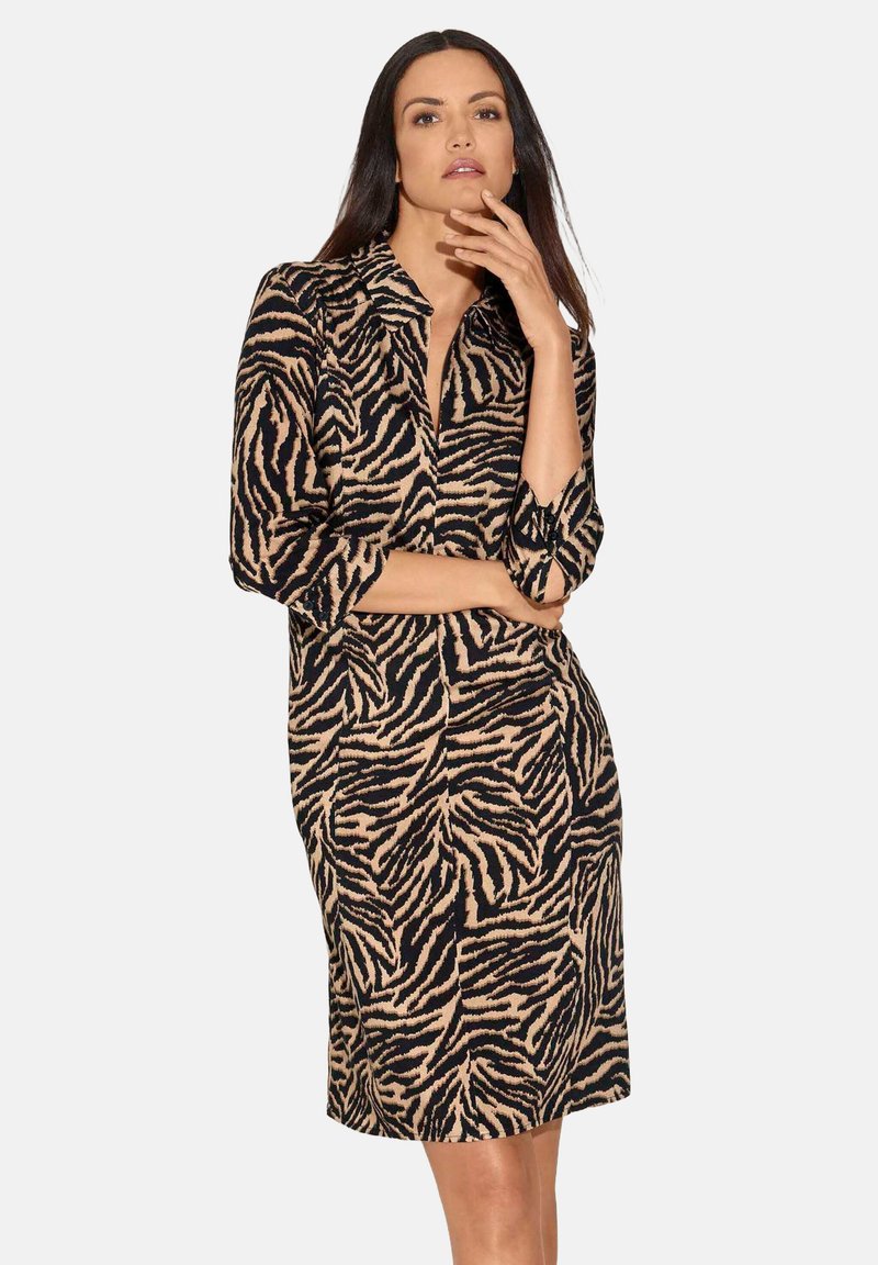Knielanges Hemdkleid mit schwarz-beigem Tigerstreifenmuster. Verfügt über lange Ärmel und eine gerade Passform. Aus glattem Stoff gefertigt.