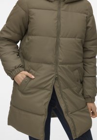 Olivengrønn dunjakke med hel glidelås, elastiske mansjetter og sidelommer. Har en glatt, polstret utside og hette.